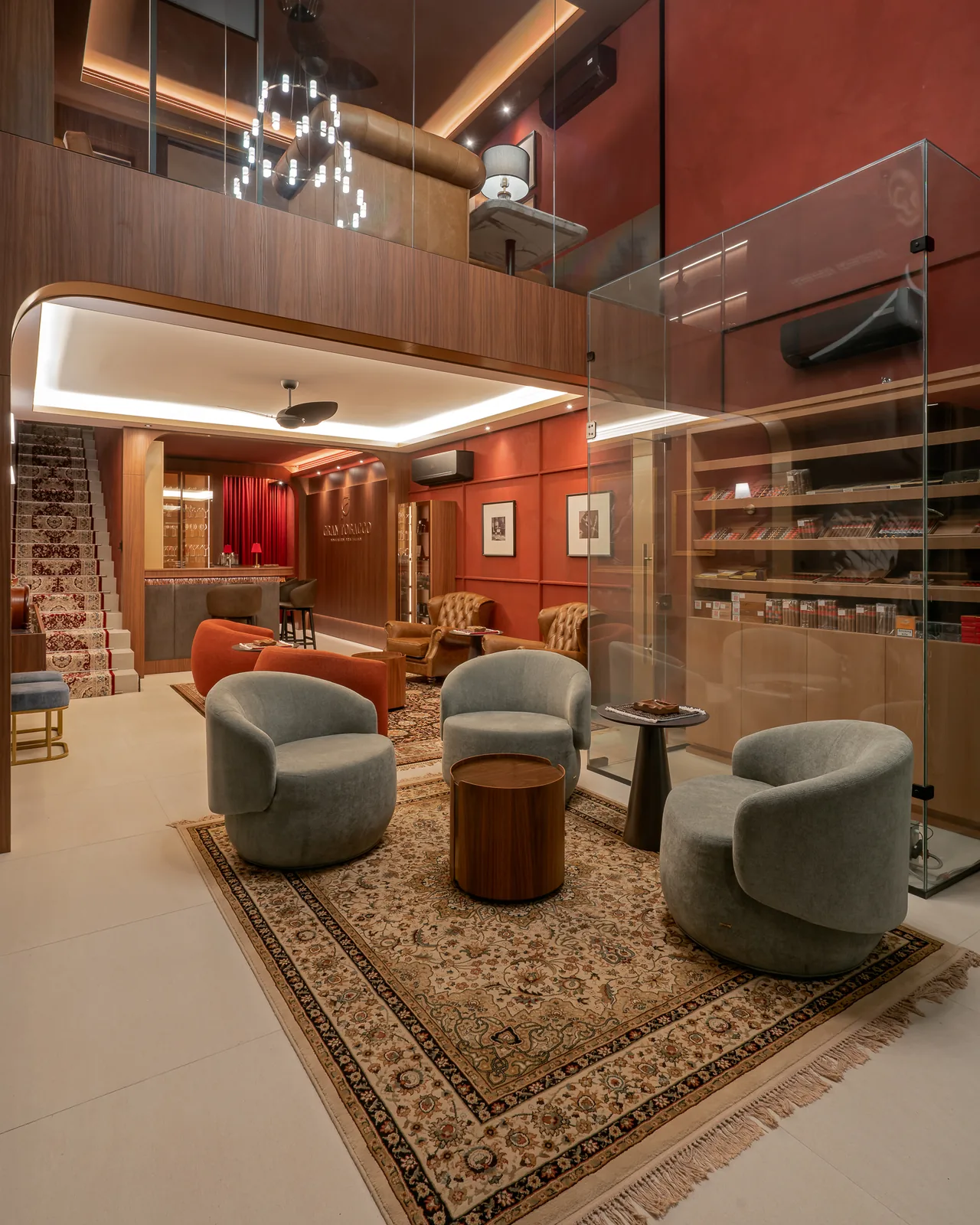 Salão do lounge Gran Tobacco com poltronas, tapete persa e umidor de charutos